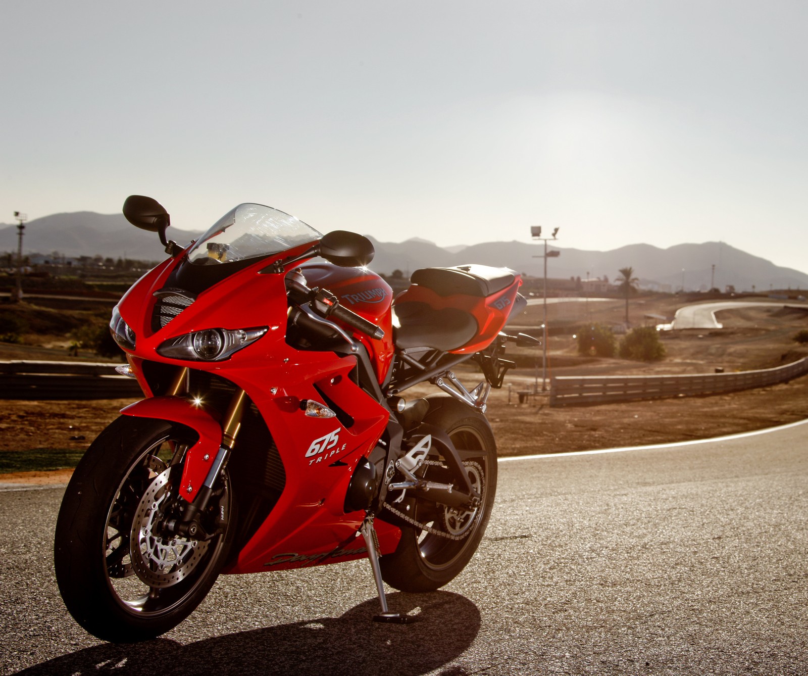 Arafed red motorcycle parked on the side of the road (675, daytona, motorcycle, triumph)