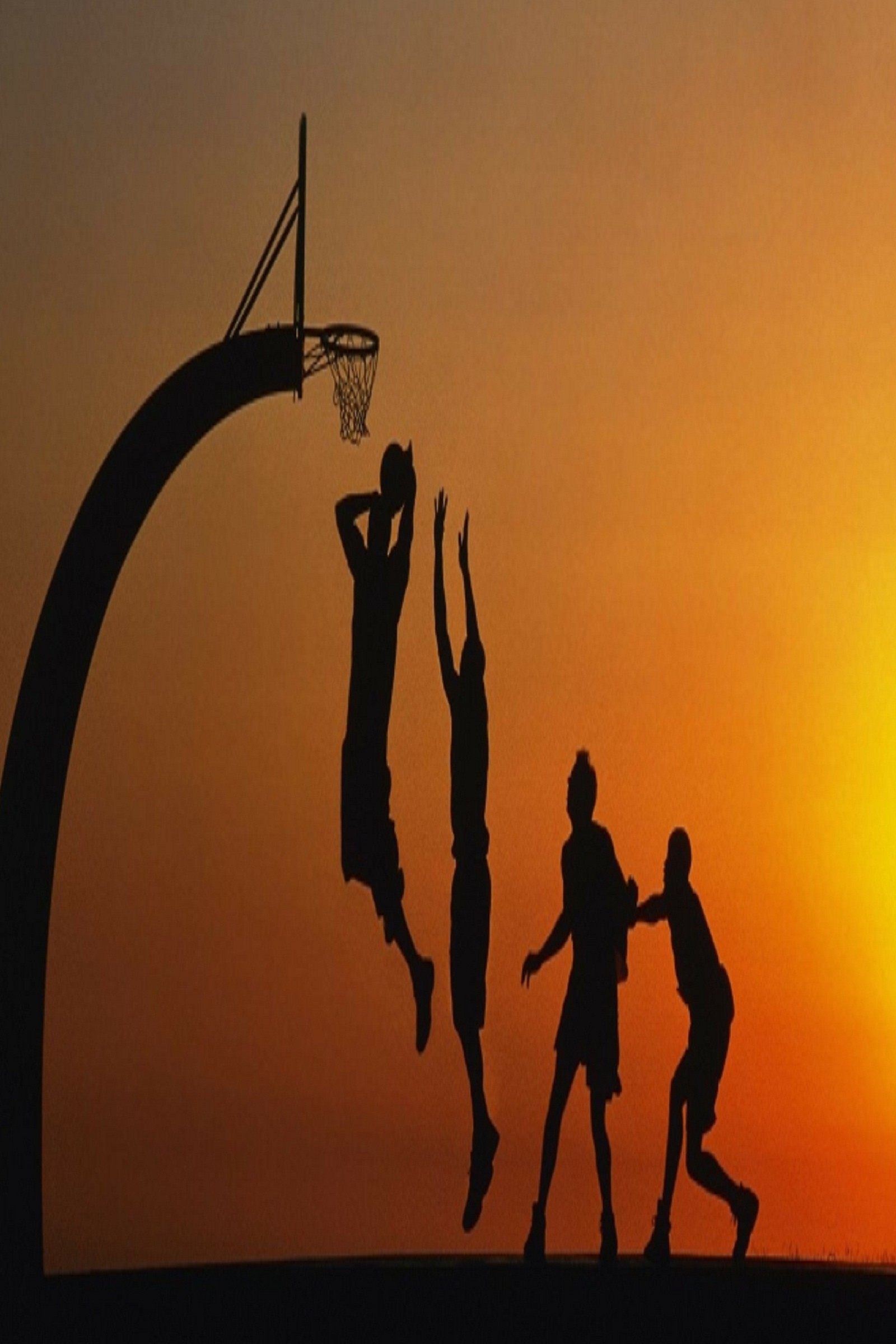 Várias pessoas estão jogando basquete ao pôr do sol em uma colina (b4, b7)