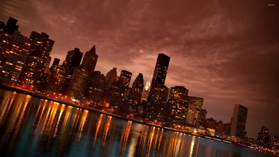 Ligne d'horizon de Manhattan illuminée au crépuscule, se reflétant sur l'eau