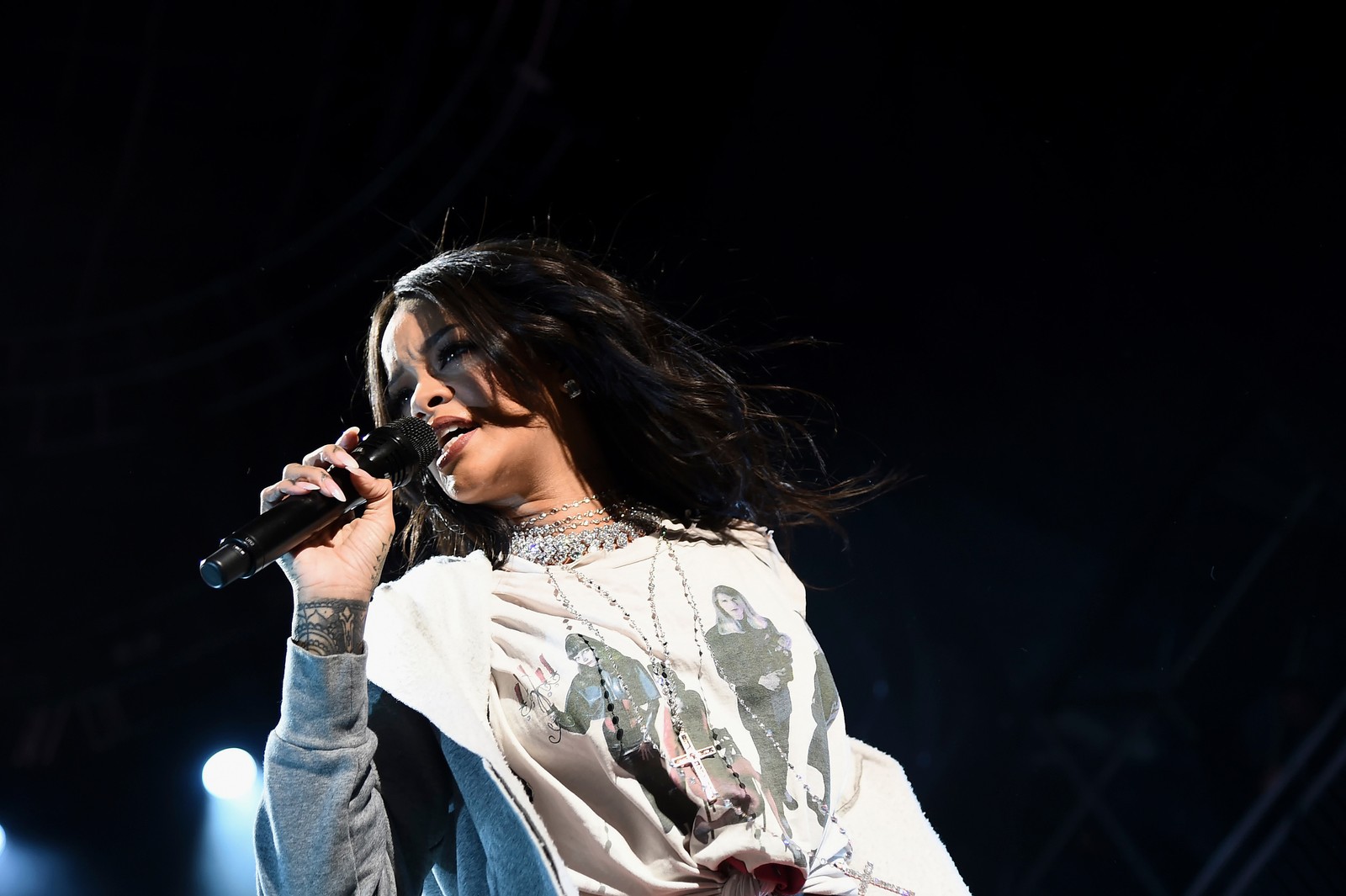 Mujer con cabello largo cantando en un micrófono en el escenario (desempeño, entretenimiento, música, cantando, artista musical)