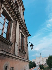 Vista de la ciudad iluminada por el sol con ventana y farol contra un cielo azul