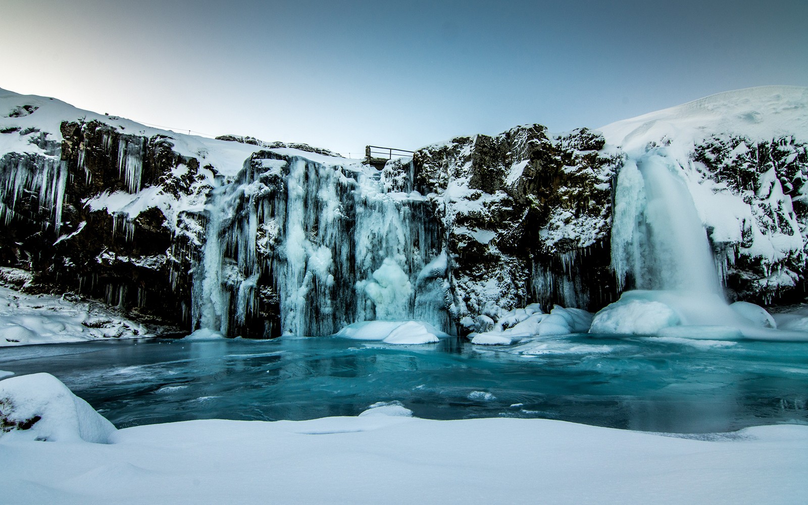 Vista aérea de una cascada en medio de un lago congelado com gelo (cascada, nieve, cuerpo de agua, agua, naturaleza)