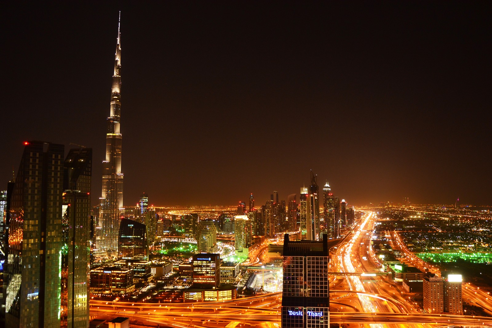 Uma visão editada de uma cidade à noite com muito tráfego (burj khalifa, paisagem urbana, metrópole, cidade, área urbana)