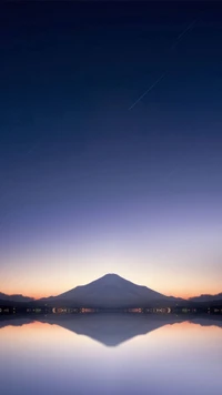 Ruhiger Dämmerung über einer bergigen Landschaft, die sich in stillen Gewässern spiegelt