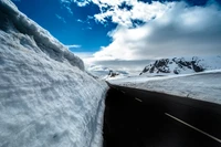 Estrada de inverno cênica cercada por majestosas montanhas cobertas de neve e gelo