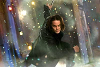 Taylor Kitsch como Gambit en una escena invernal dinámica llena de confeti y nieve.