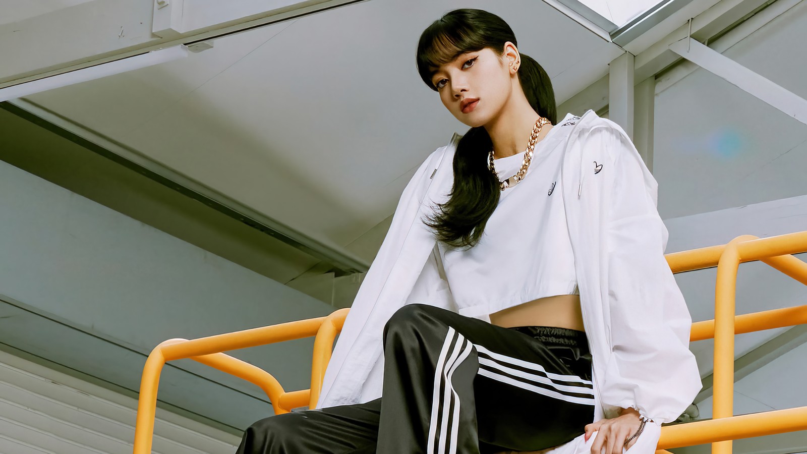 Una mujer árabe con una camisa blanca y pantalones negros sentada en una balaustrada amarilla (lisa, lalisa manoban, ลลสา มโนบาล, pranpriya manoban, ปราณปรยา มโนบาล)