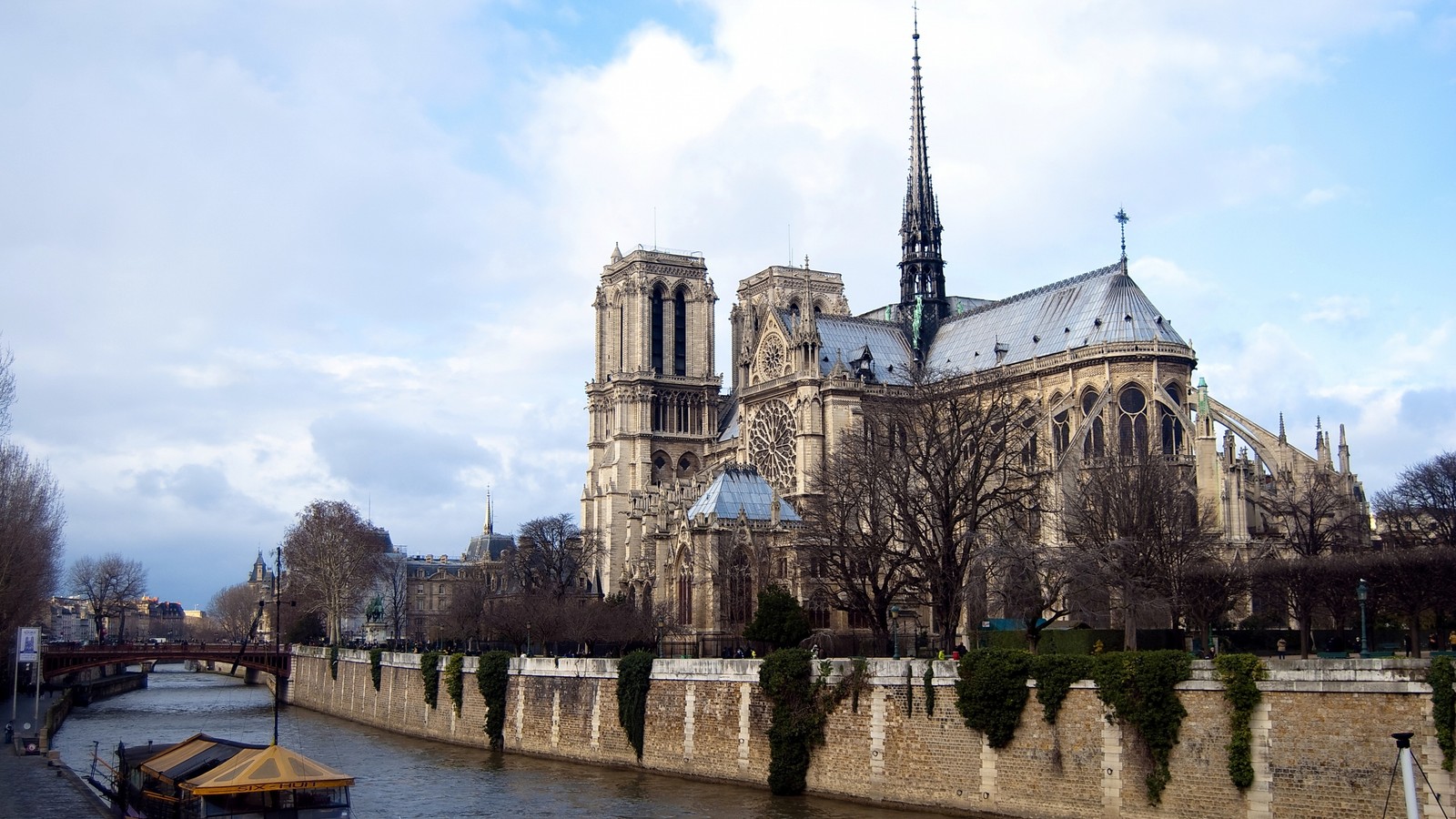 Arafed view of a large cathedral with a boat on the river (notre dame de paris, seine, cathedral, waterway, river)