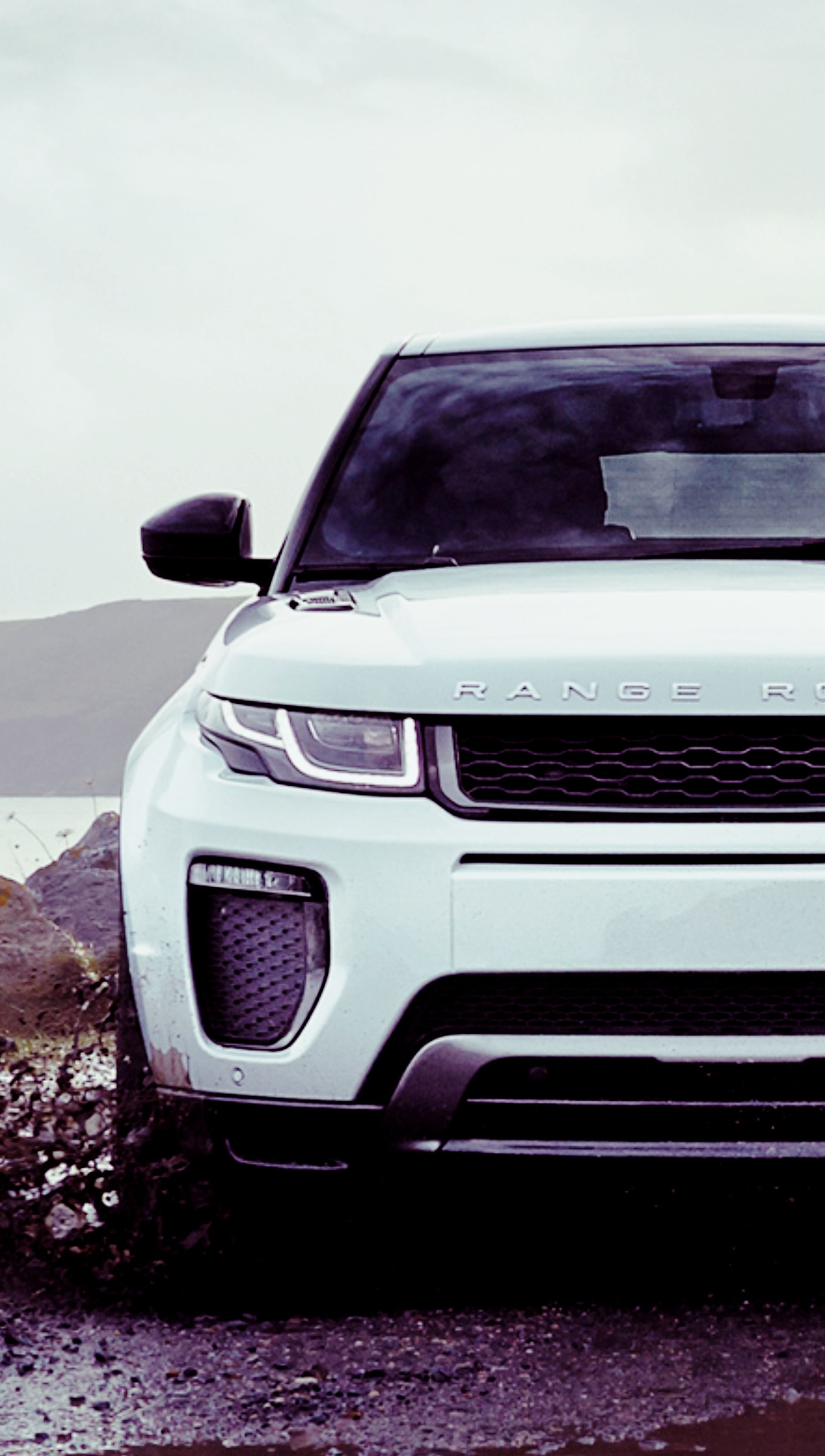 Arafed white car parked on a rocky road near a body of water (car, evoque auto, range rover, range rover evoque)