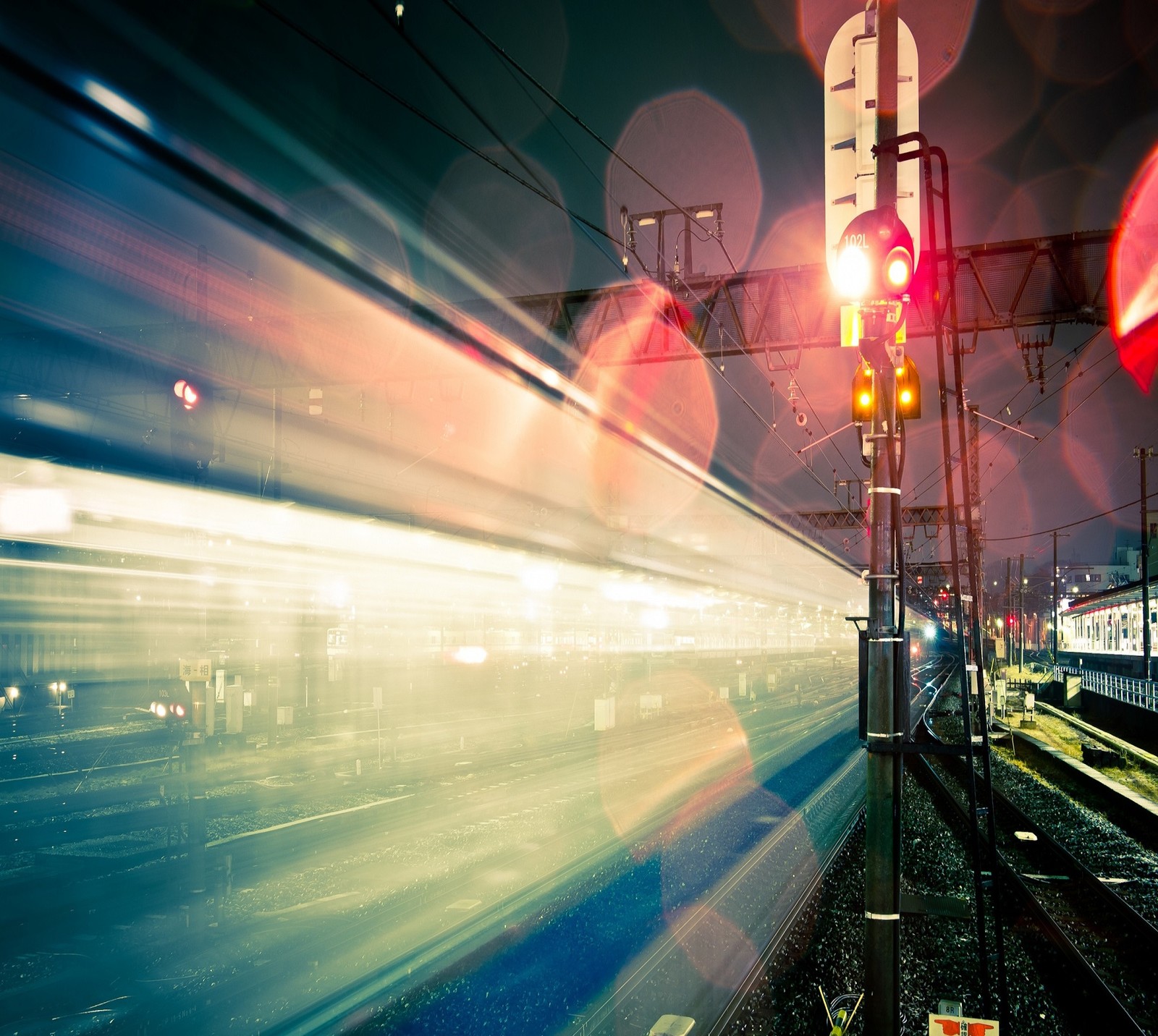 Um trem passando por uma estação de trem à noite com luzes acesas (galáxia, luz, m8, vermelho, s3)