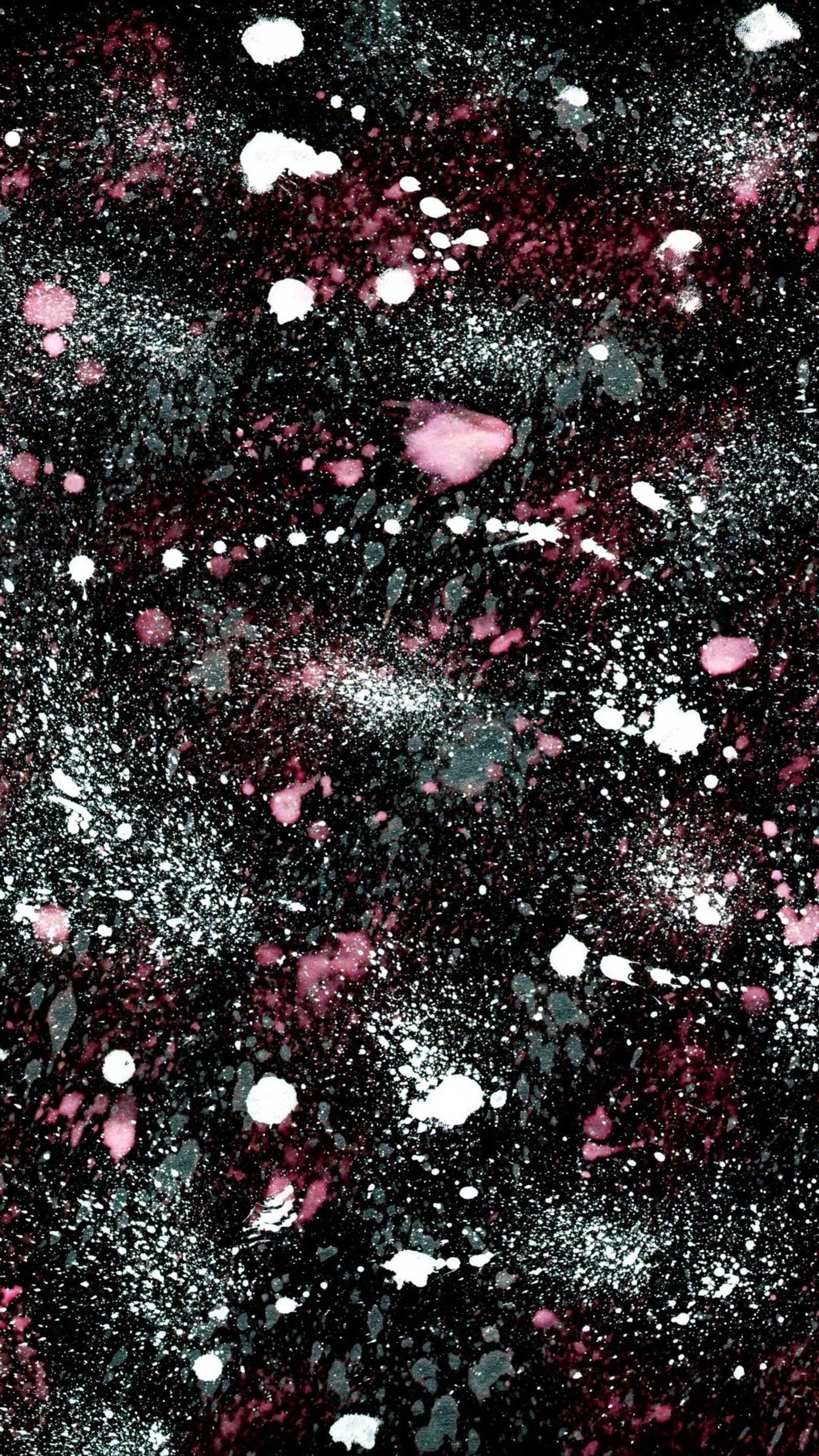 A close up of a black and pink background with white spots (paint, splatter)