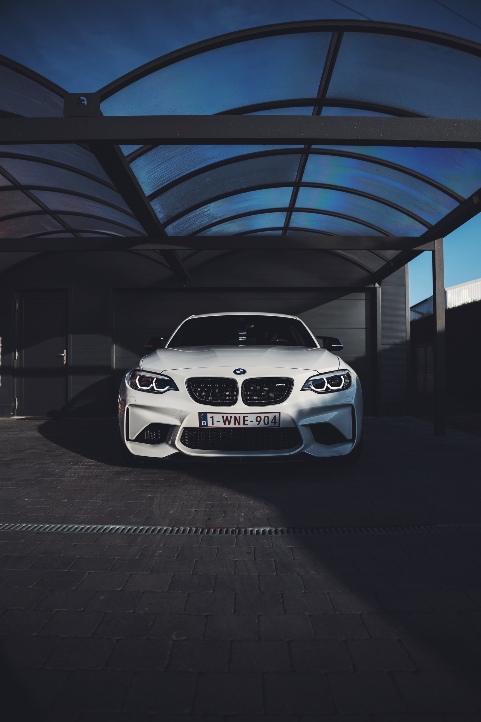 A close up of a white bmw car parked in a garage (grille, bmw m3, bmw m6, sedan, bumper)