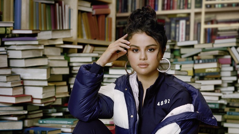 Аэрофотоснимок женщины, сидящей перед стопкой книг (селена гомес, selena gomez, пума, студент, музыкант)