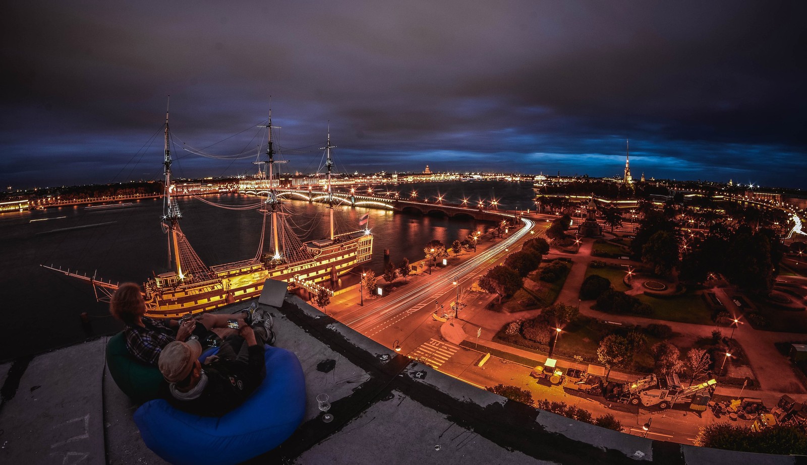 Uma vista de uma cidade à noite com um barco na água (noite, cidade, anoitecer, horizonte, linha do horizonte)