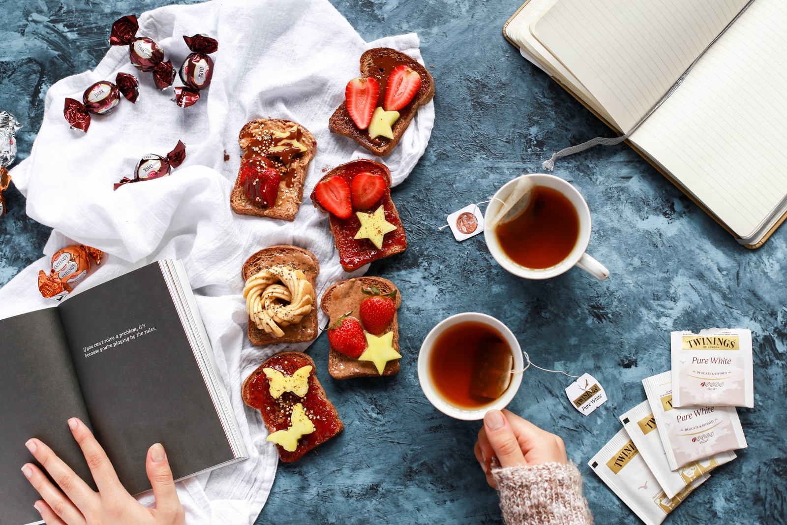 Alguien está leyendo un libro y comiendo un sándwich con fresas (restaurante, comida, brunch, desayuno, cocina)