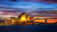 Sydney Opernhaus beleuchtet bei Dämmerung mit der Harbour Bridge im Hintergrund