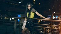 Giselle from Aespa poses stylishly at night, showcasing a bold outfit against a vibrant urban backdrop.