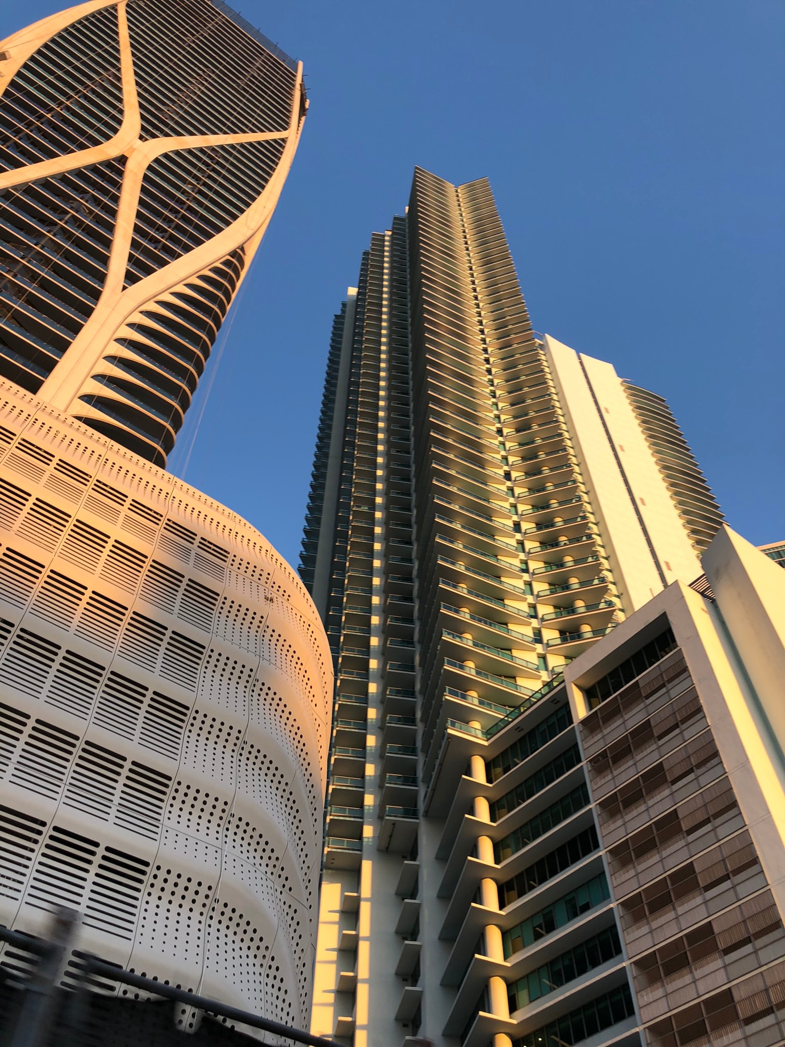 Des immeubles hauts dans une ville avec un ciel bleu en arrière-plan. (miami, bleu, immeuble tour, journée, architecture)