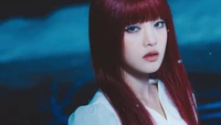 Minnie do (G)I-DLE com cabelo vermelho marcante e maquiagem dramática, capturada em um ambiente sombrio e etéreo.