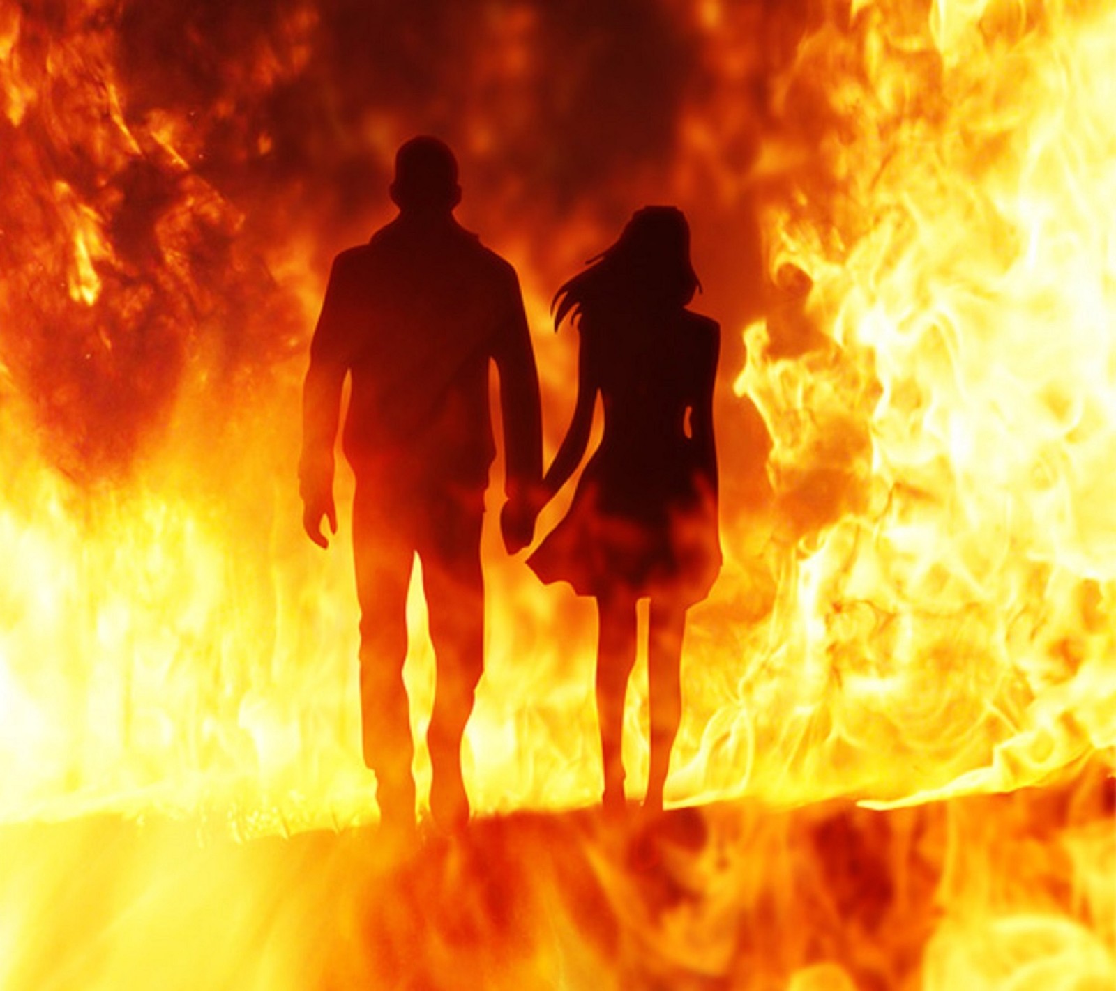 Un couple s'éloignant d'un feu avec des flammes en arrière-plan (couple, feu, se tenant la main, je taime, amour)