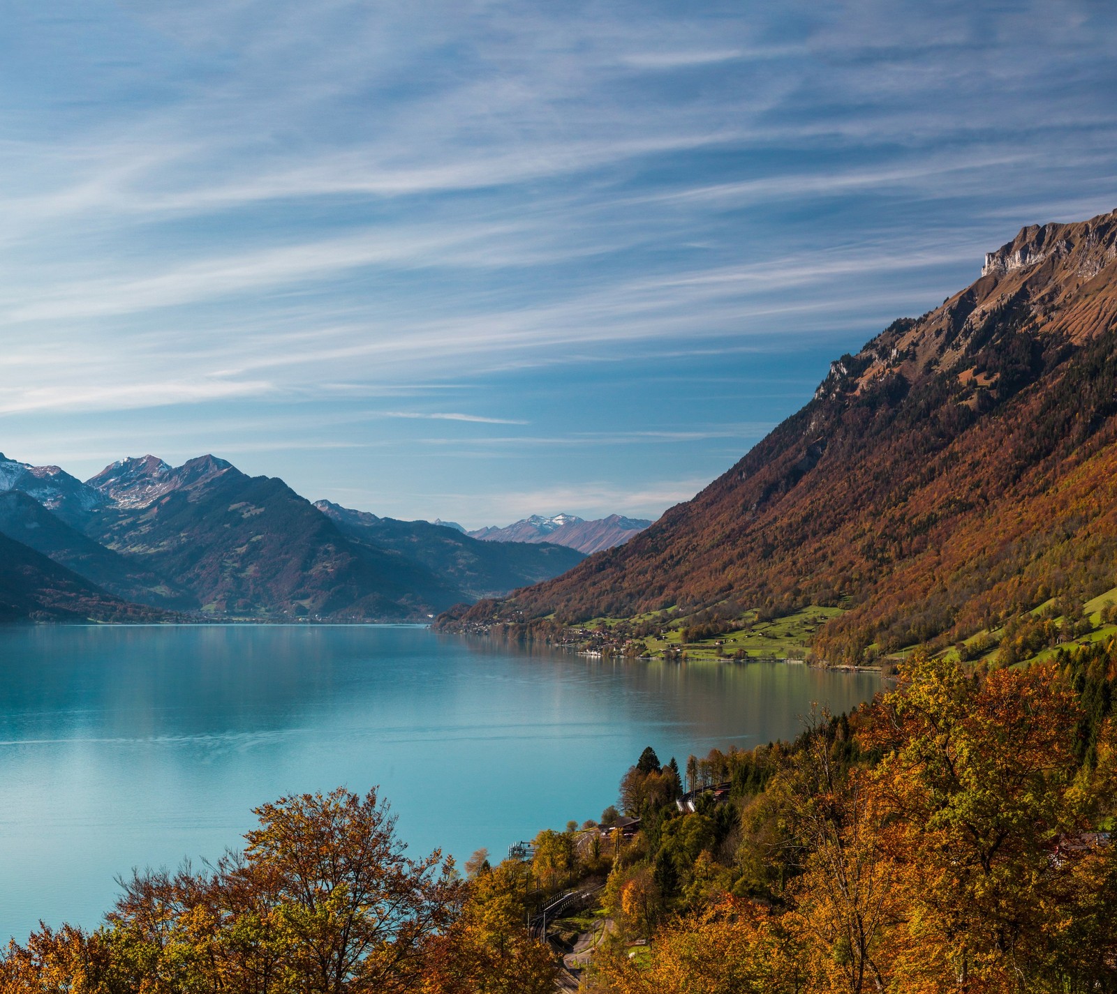 Montañas y un lago en medio de un valle con algunos árboles (lago, montañas, árboles, agua)