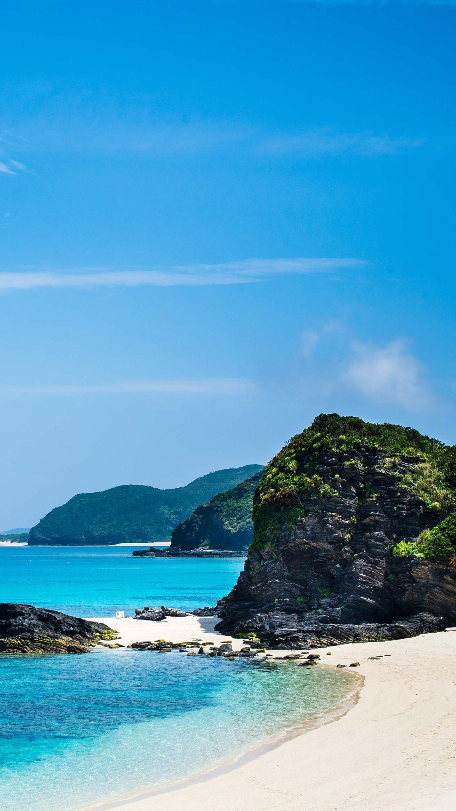 Hay una playa de arena blanca con un océano azul y una montaña de fondo (nuevos fondos de pantalla, 2020, 2019, océano, agua)