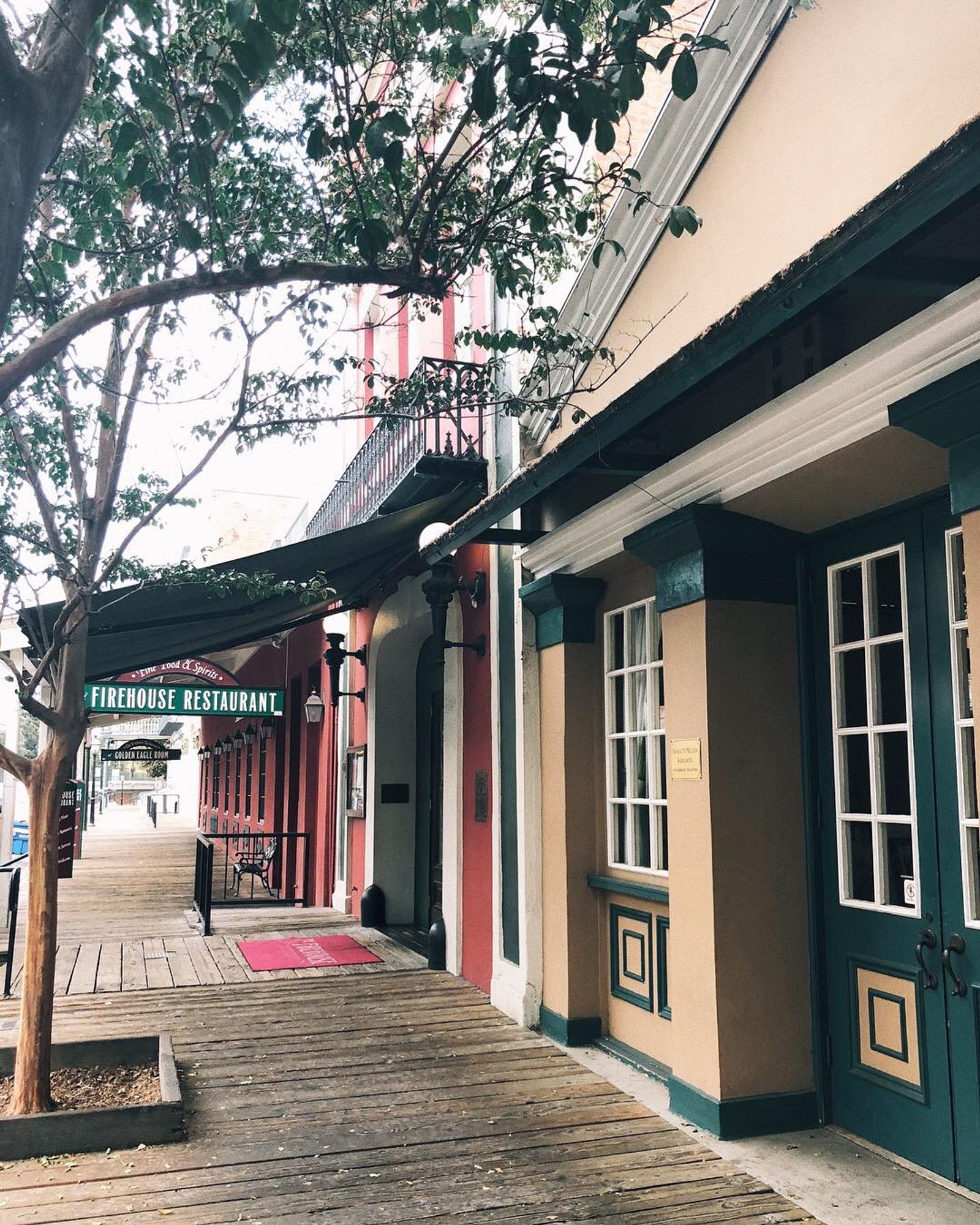 There is a wooden walkway that leads to a building with a sign on it (house, real estate, architecture, neighbourhood, street)