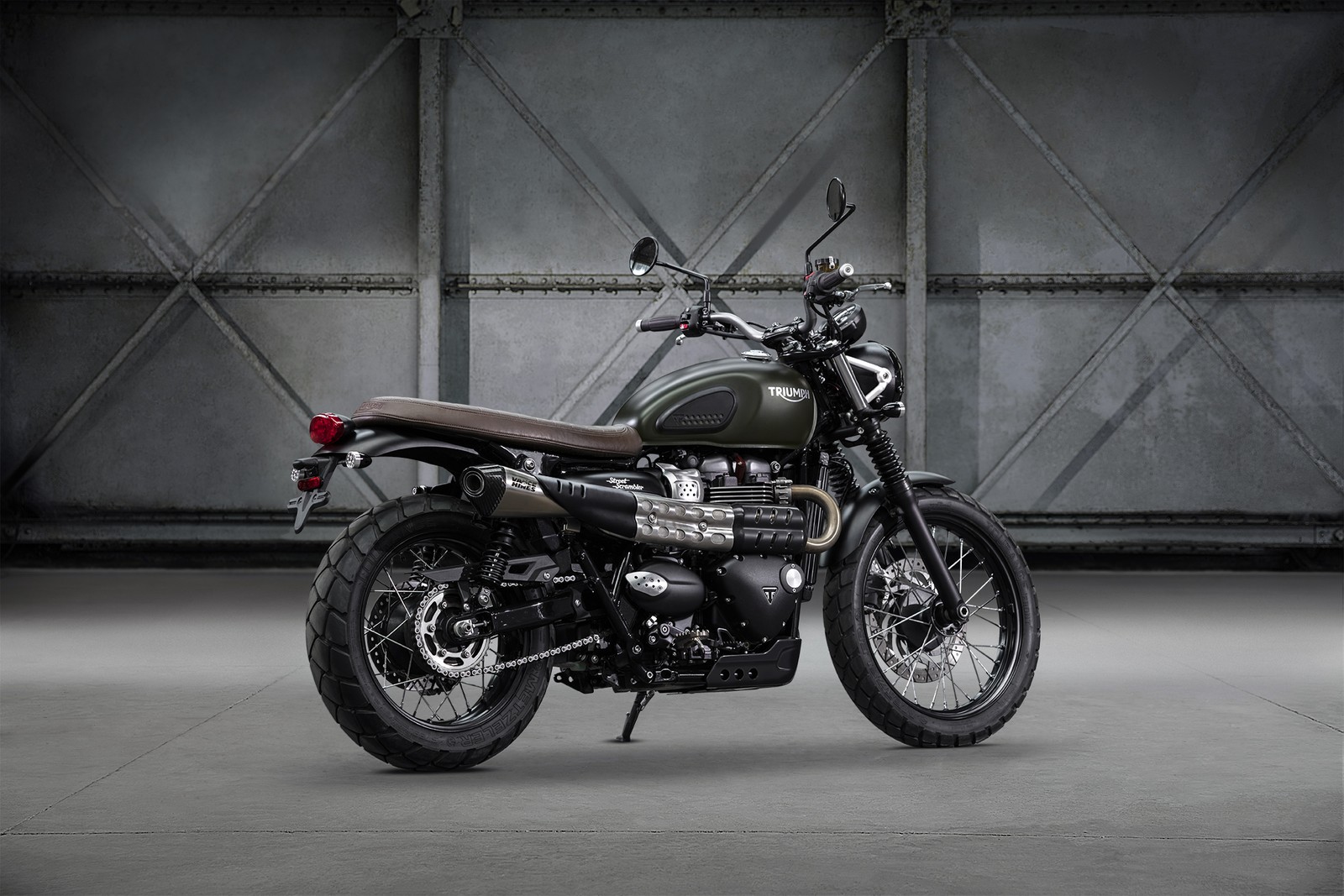 Nahaufnahme eines motorrads, das in einer garage geparkt ist (triumph motorcycles ltd, triumph scrambler, motorad, auto, autoreifen)