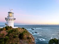 Phare côtier au coucher du soleil : un phare sur le promontoire