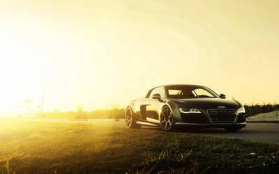 Sleek Audi sports car with a V10 engine, parked on an open road at sunset, showcasing its stunning automotive design.