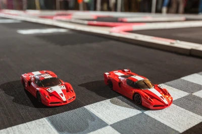 Carros de corrida Ferrari em miniatura na linha de chegada de uma pista