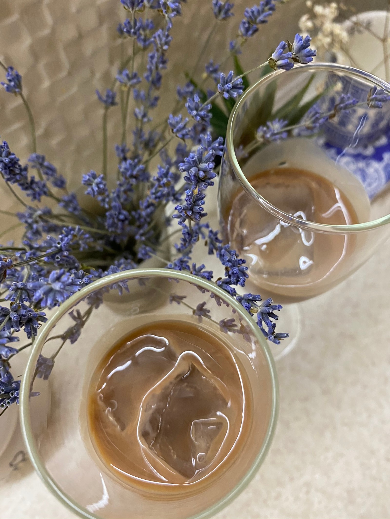 There are two glasses of liquid with ice in them on a table (cup, serveware, liquid, drinkware, drink)