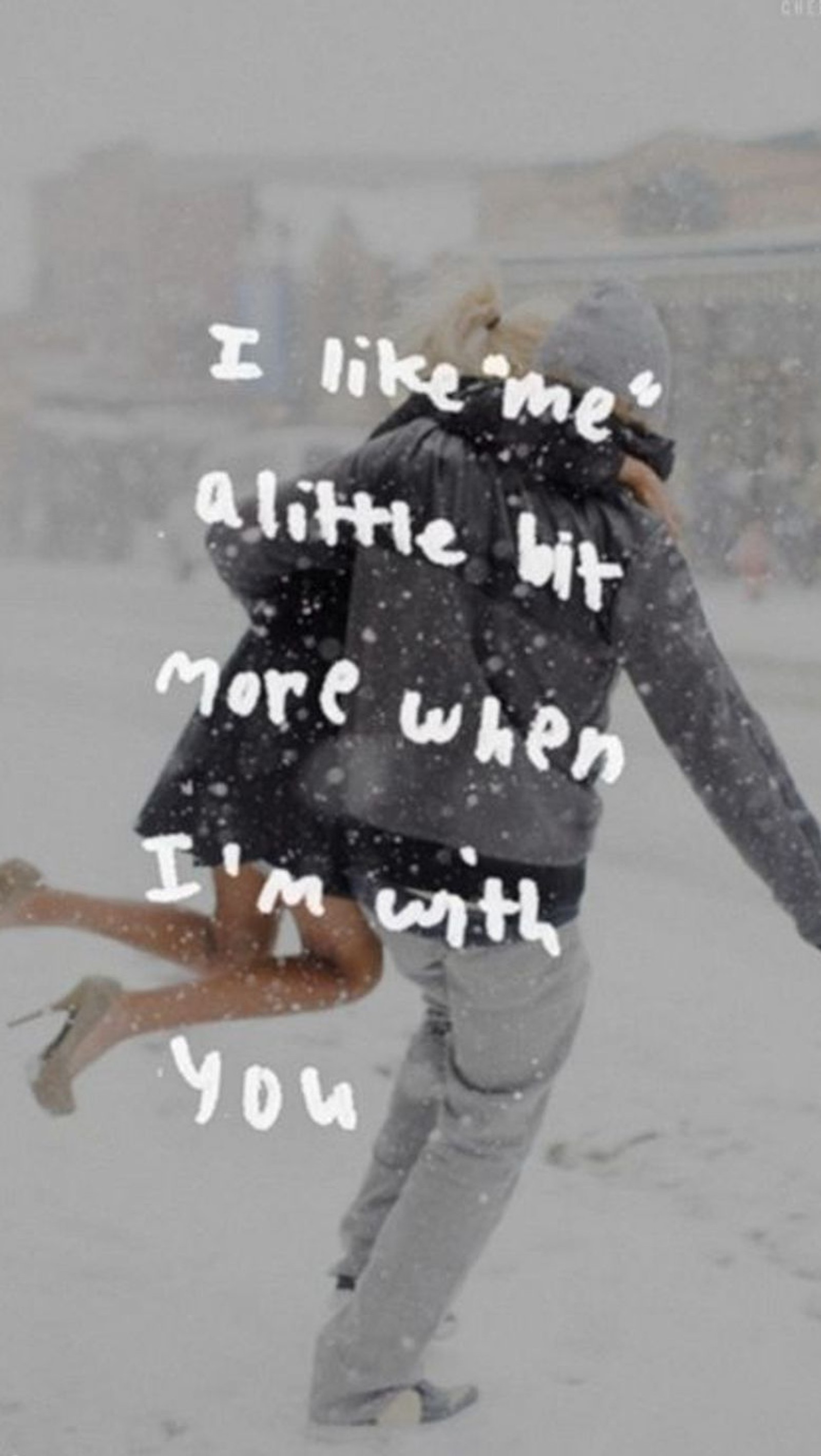 A couple is hugging in the snow with a quote on it (love, lovers, quote, winter)