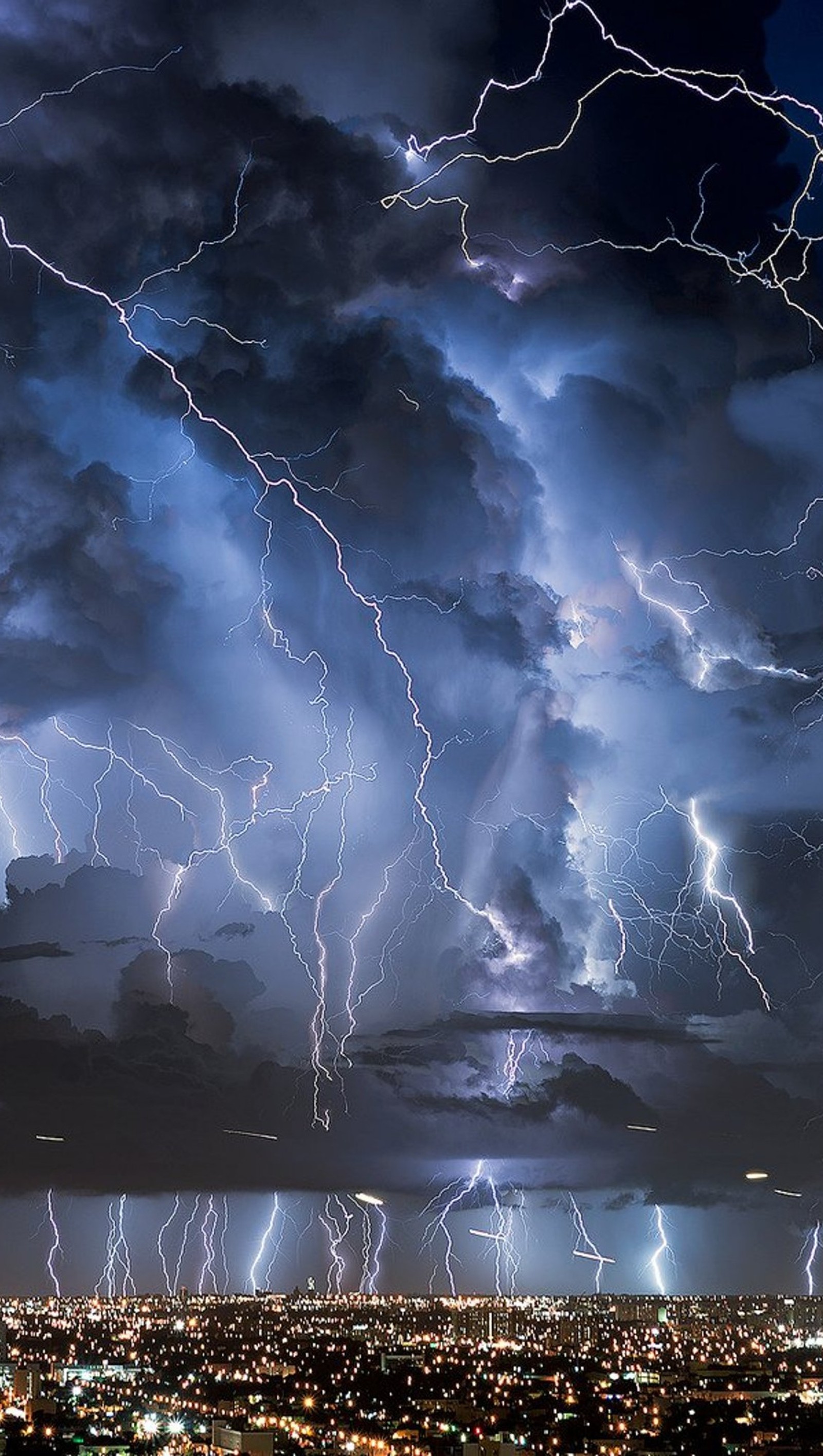 Des éclairs frappent une ville la nuit sous un ciel sombre (ville, éclair, tempête)