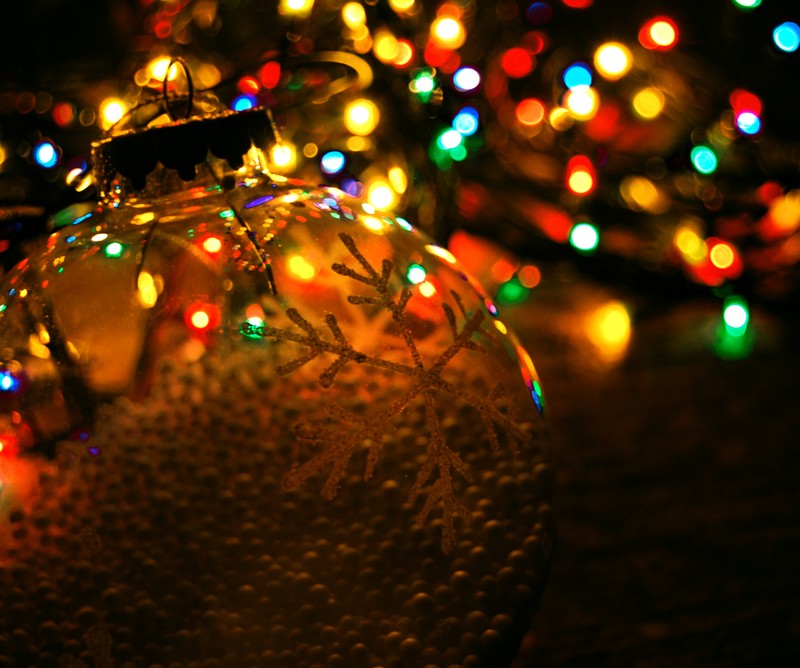 Adorno navideño iluminado brilla en una mesa frente a un fondo oscuro (2013, navidad, color, deseo, galaxia)