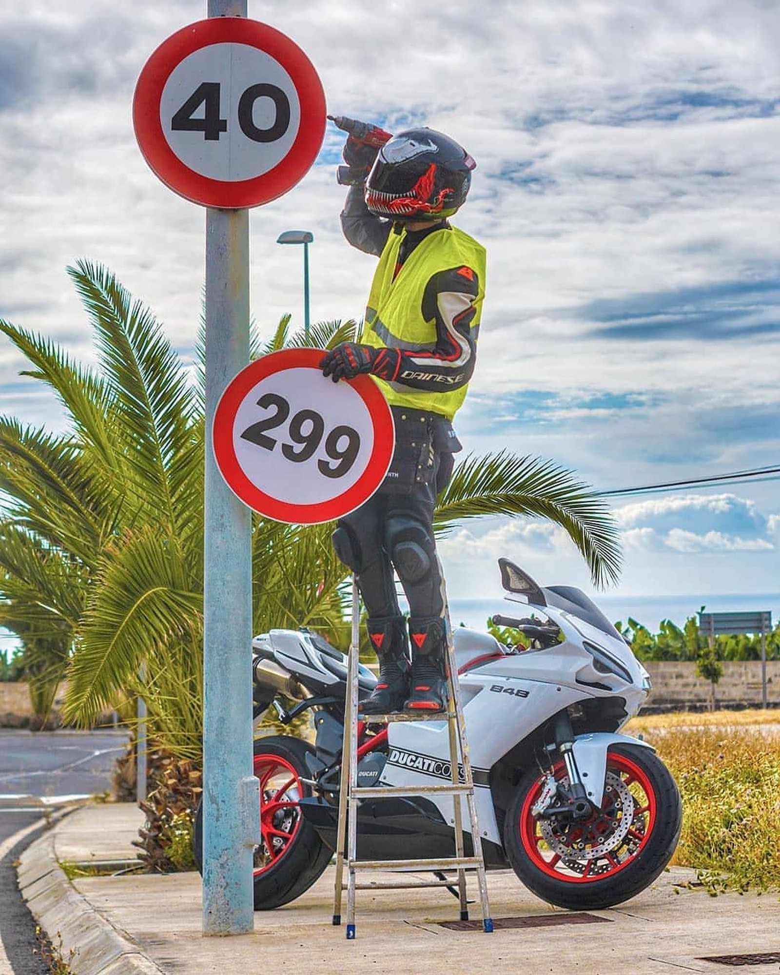 Vista aérea de un hombre en una escalera junto a una señal de límite de velocidad (kawazaki, moto)