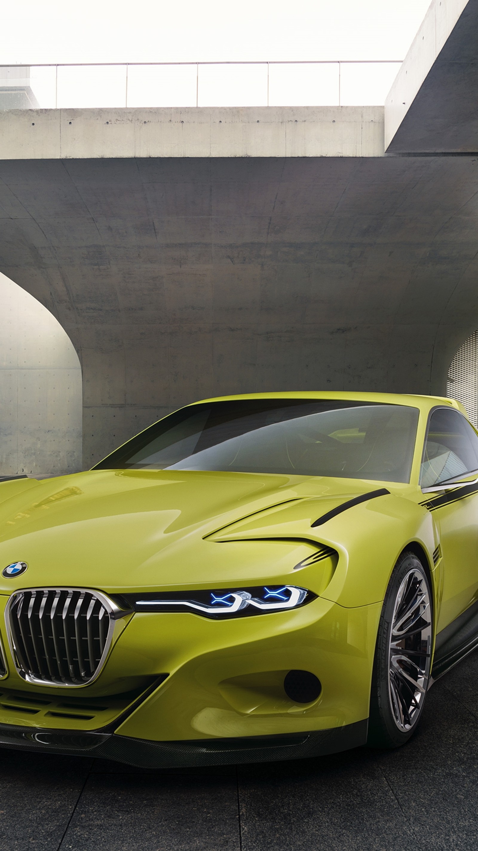 A close up of a yellow bmw sports car parked under a bridge (auto, bimmer, bmw, car, concept)