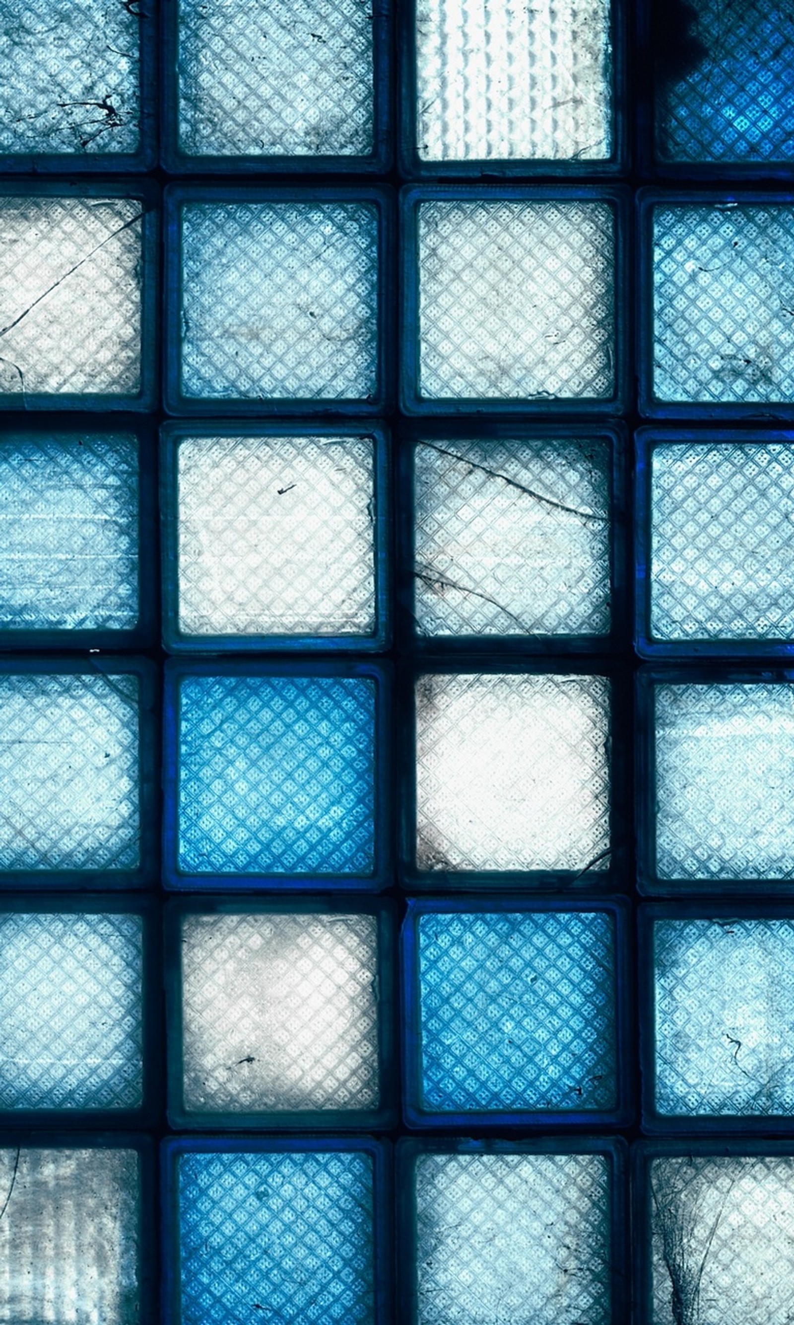 A close up of a window with a blue glass block pattern (abstract, blue, sqaures)