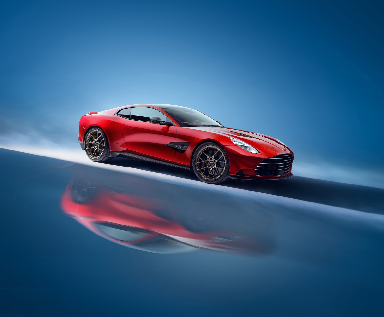 Новый aston gt показан в красном цвете (aston martin vanquish, 2024, 5k, 8k, синий фон)