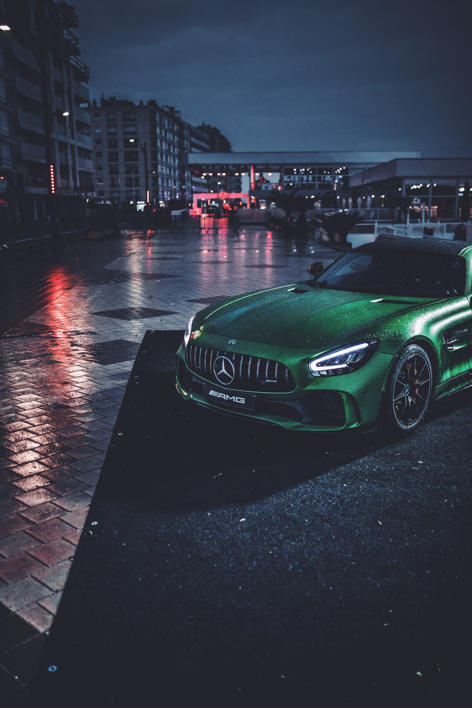 A close up of a green sports car parked on a wet street (automotive lighting, sports car, king, automotive exterior, compact car)