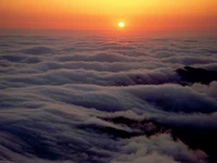 Aube matinale : Un lever de soleil serein sur une mer de nuages