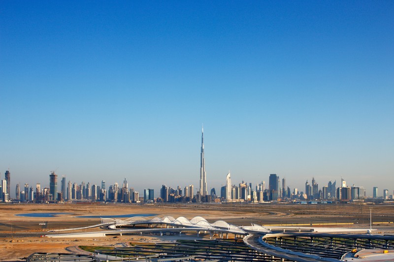 Вид на город с множеством зданий и самолетом (burj khalifa, городской пейзаж, город, горизонт, городская территория)