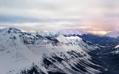 Amanecer brumoso sobre montañas glaciares cubiertas de nieve