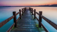 Holzbrücke, die ins ruhige Meer bei Dämmerung führt