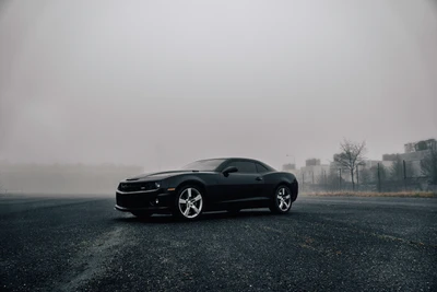 Elegante Chevrolet muscle car negro en un entorno brumoso