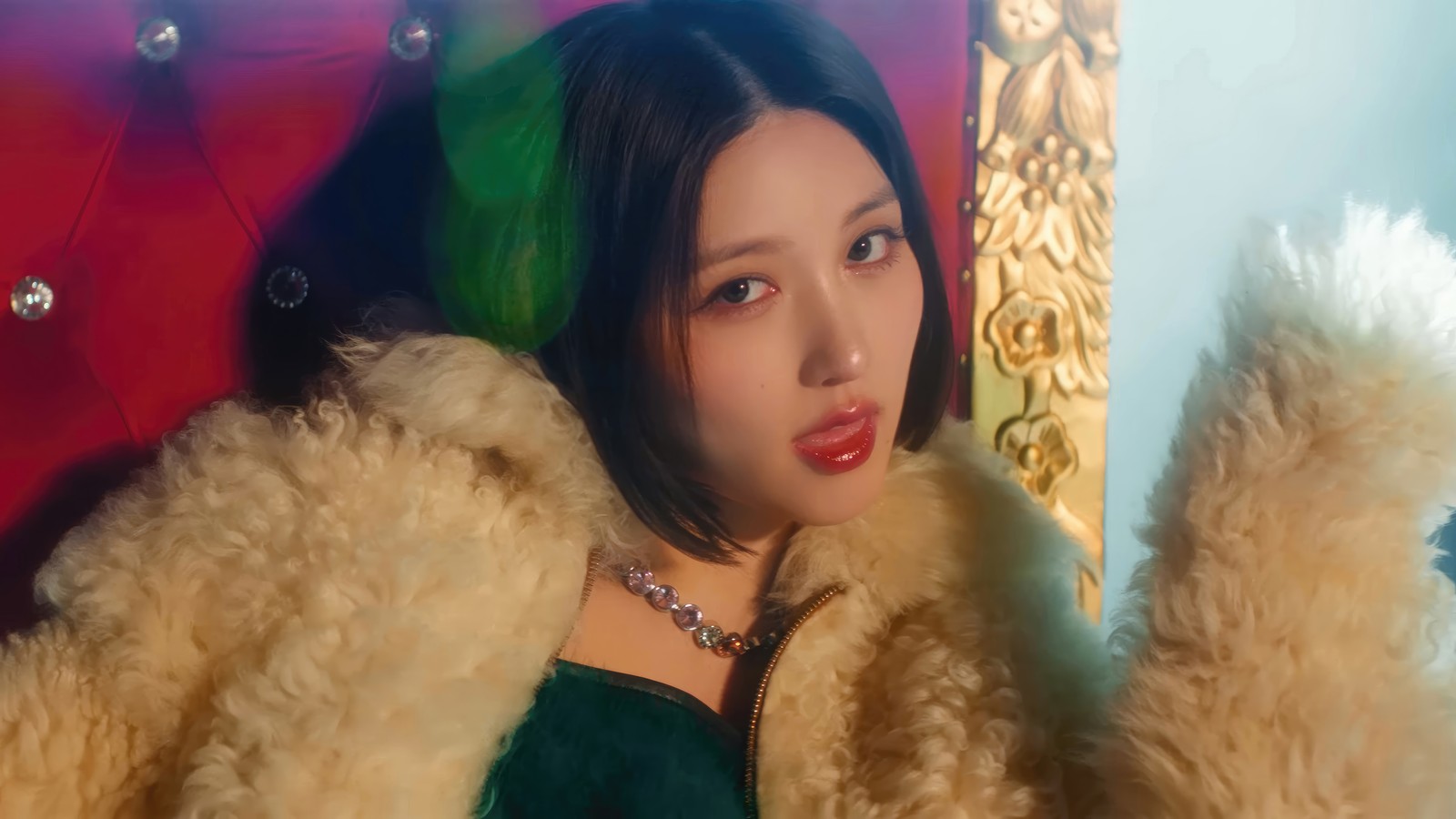 Femme arabe avec des cheveux verts et un manteau en fourrure sur une chaise rouge (ive, 아이브, kpop, coréen, groupe de filles)