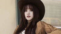 Song Yuqi con un atuendo inspirado en Occidente y un sombrero, mostrando una mirada confiada