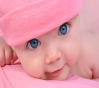 Bébé adorable en rose avec des yeux bleus captivants