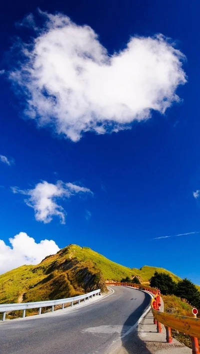 Nuage en forme de cœur au-dessus d'une route de montagne pittoresque