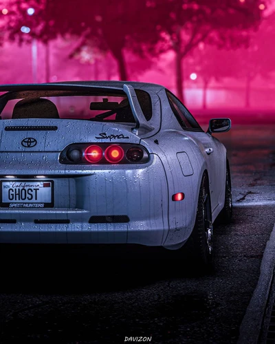 Toyota Supra in a moody, neon-lit setting with a California license plate reading "GHOST.